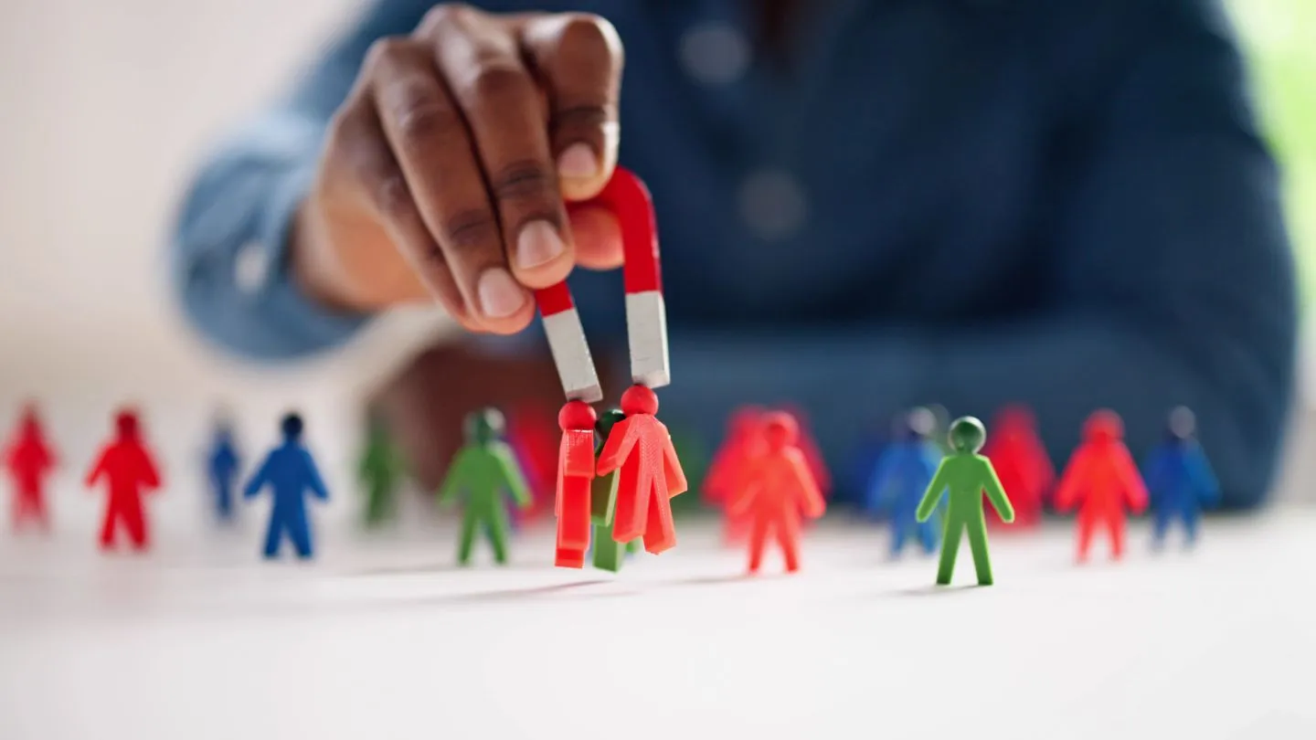 Magnet attracting colorful people figures representing real estate lead generation strategies that pull in qualified buyers and sellers