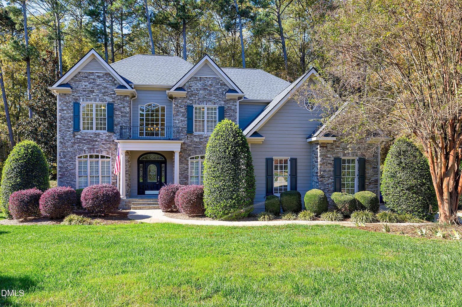 Stately stone and stucco exterior with manicured landscaping